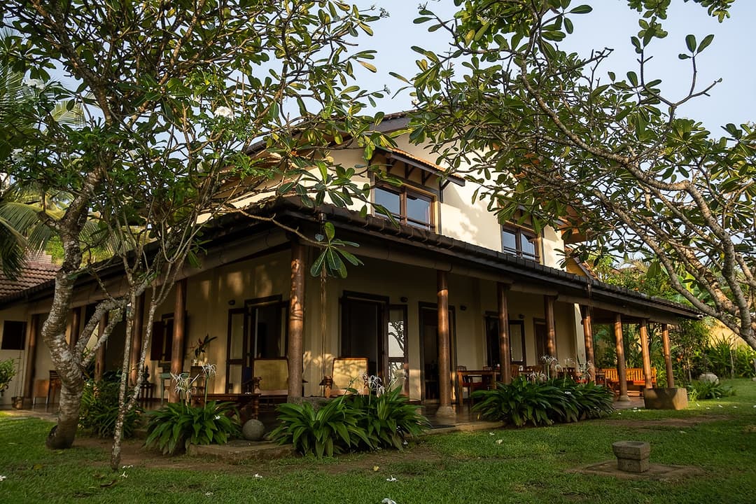 Villa Tres Matara exterior surrounded by lush tropical trees and garden