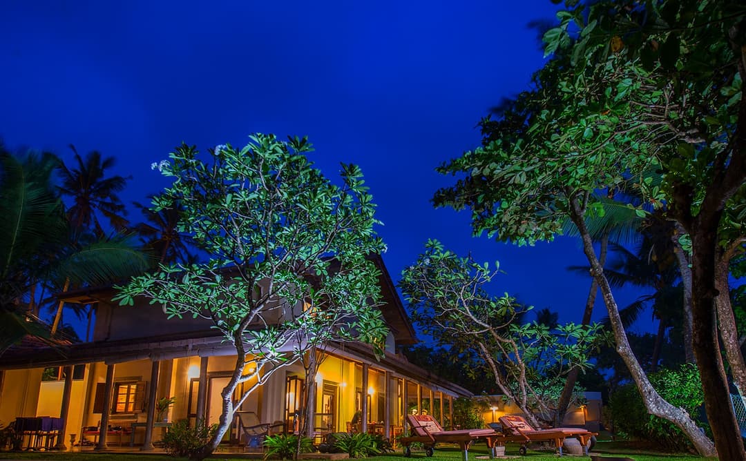 Villa Tres Matara exterior fully illuminated at night against dark sky