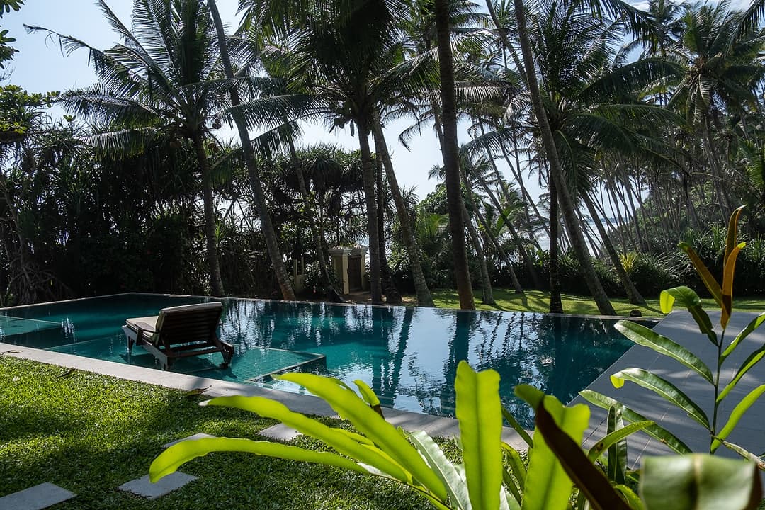 Villa Tres Matara pool with tropical garden, coconut palms and ocean view