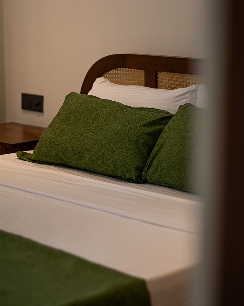 Villa bedroom with green linen accents and garden view