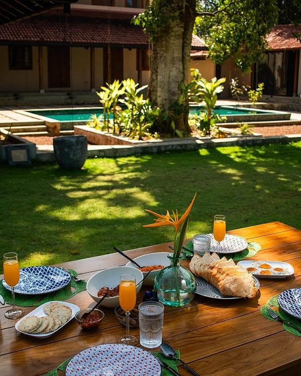Dining table set for lunch with tropical garden setting