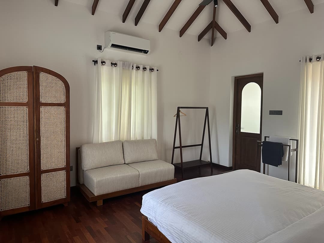 Master bedroom with white linen and arched windows