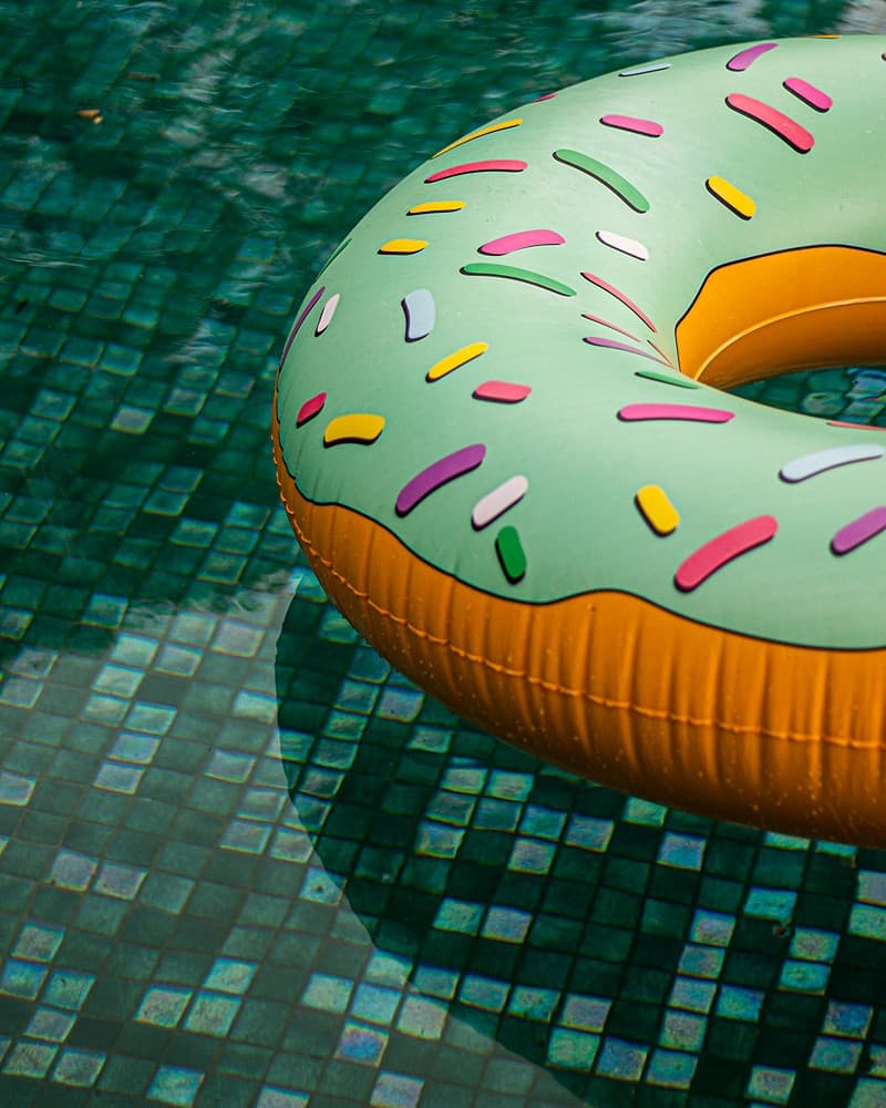 Pool with colourful inflatable ring on turquoise tiled water