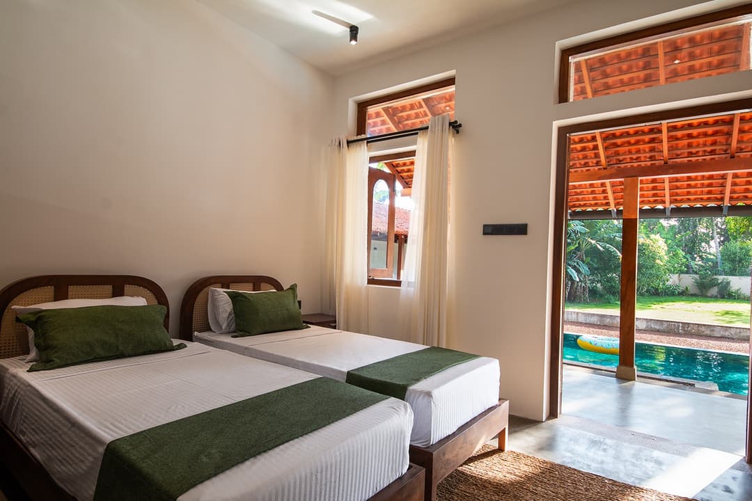 Twin bedroom with direct pool access through glass doors