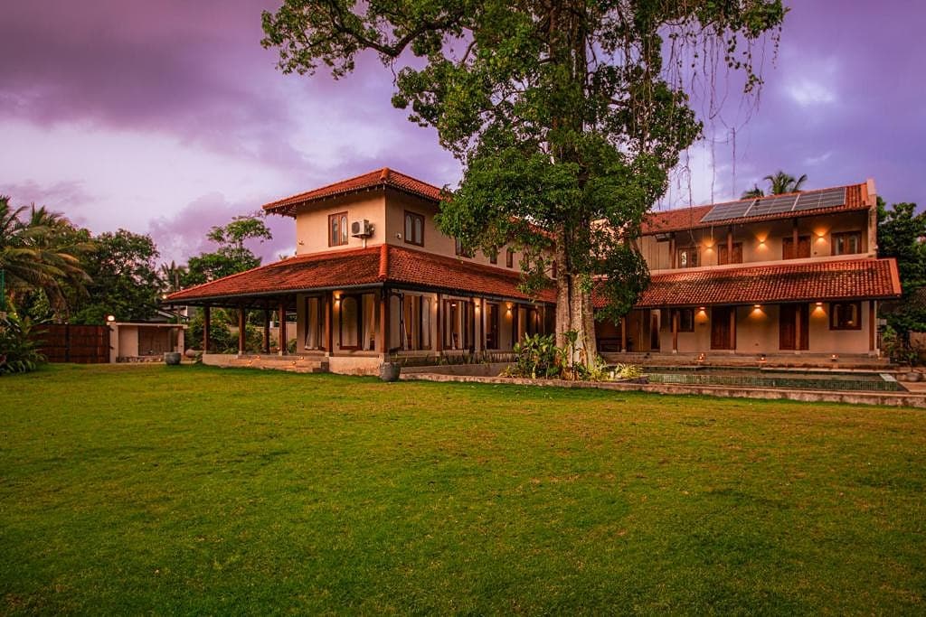 Origin Balapitiya villa exterior illuminated at dusk with tropical garden