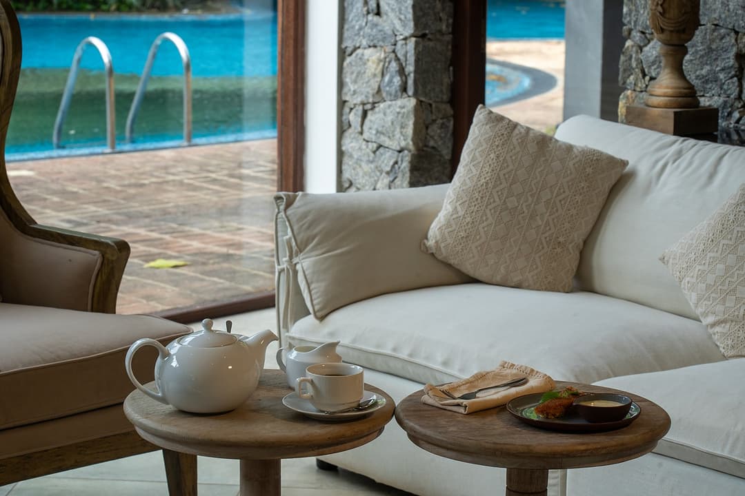 Poolside lounge with cushioned seating and ocean backdrop