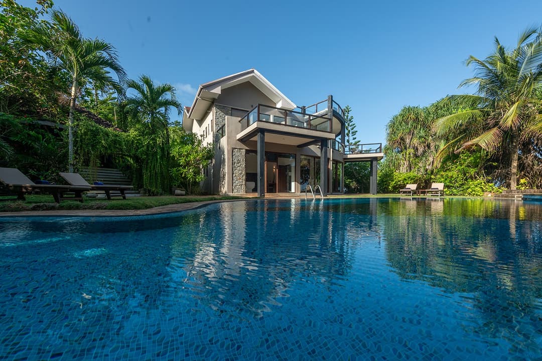 Casa Tua pool with villa reflection under clear blue sky