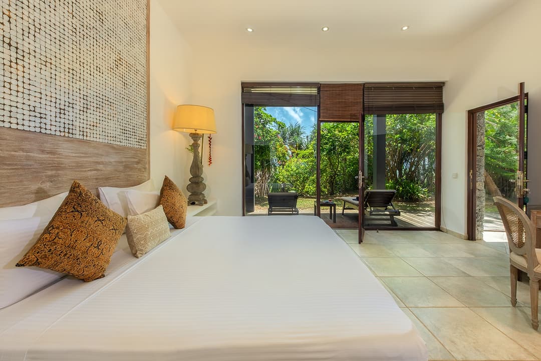Casa Tua bedroom with king bed and ocean view through glass doors
