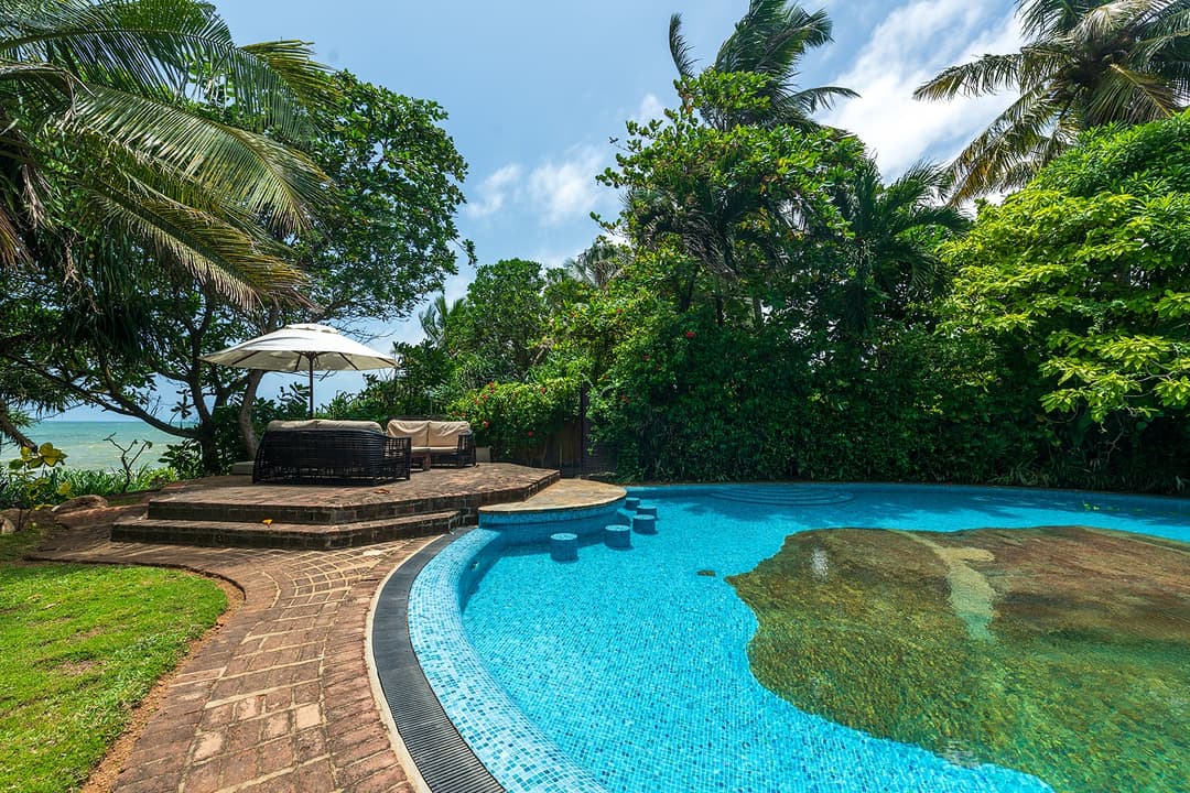 Pool terrace with stone paving and tropical garden planting