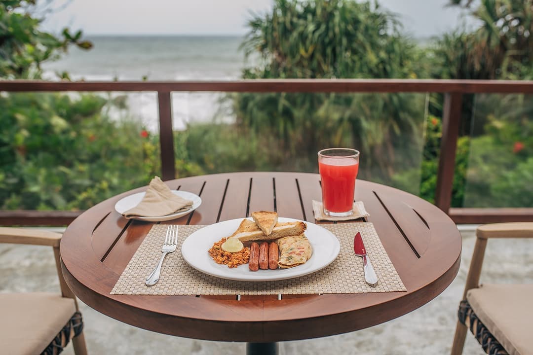 Outdoor breakfast table with ocean view and fresh food