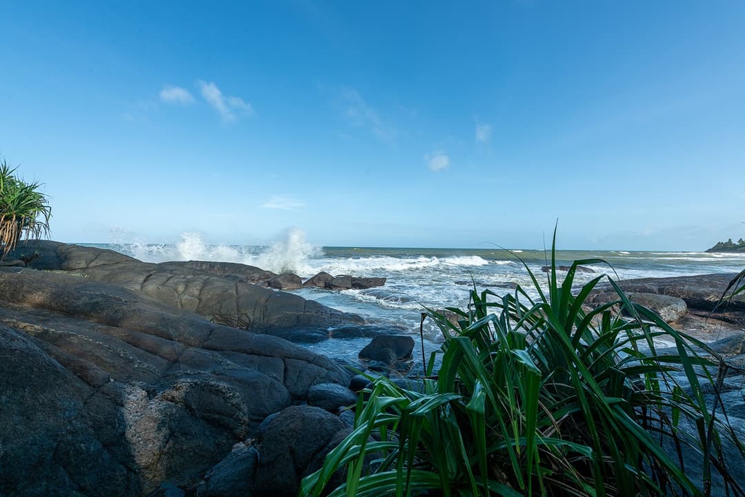 Rocky shoreline with ocean boulders at beachfront villa