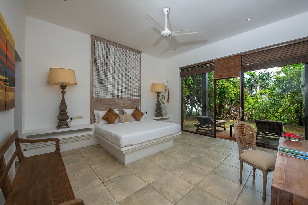 Villa bedroom with white linen and headboard artwork