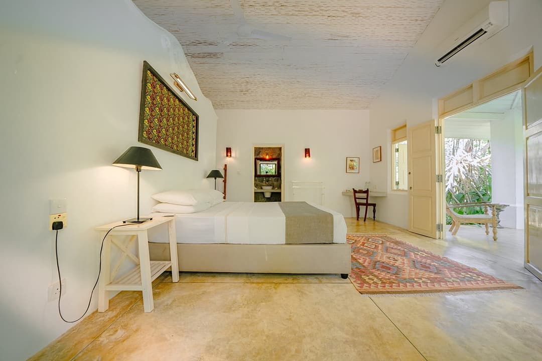 Villa bedroom with king bed and red woven rug