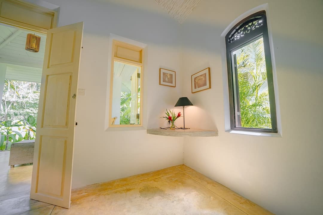 Villa bedroom with green shutters and antique lamp