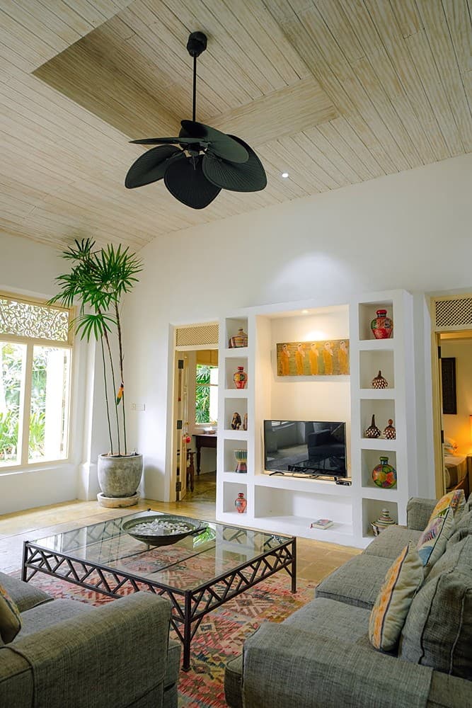 Villa bedroom with ceiling fan and crisp white linen