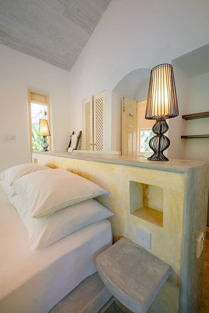 Villa bedroom with bedside lamp and warm neutral tones