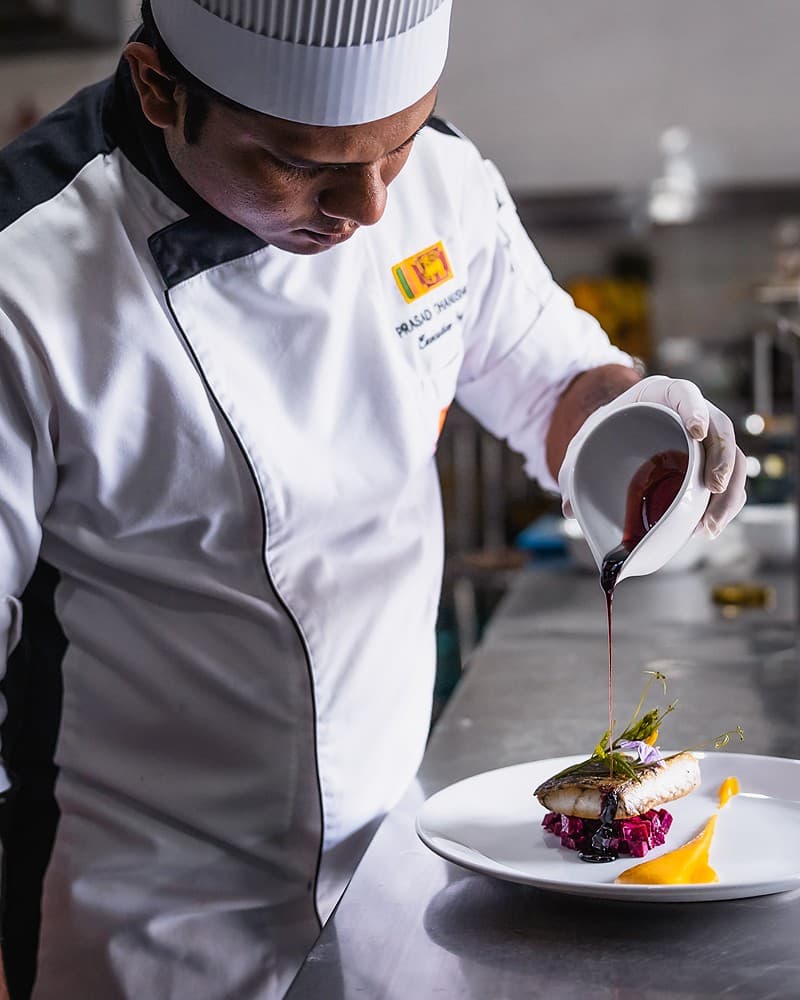 Chef carefully plating a dish in the hotel kitchen