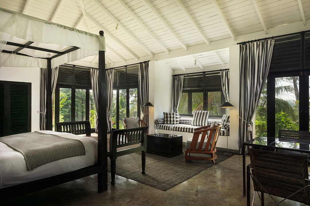 Kahanda Kanda suite with four-poster bed and seating area with garden view