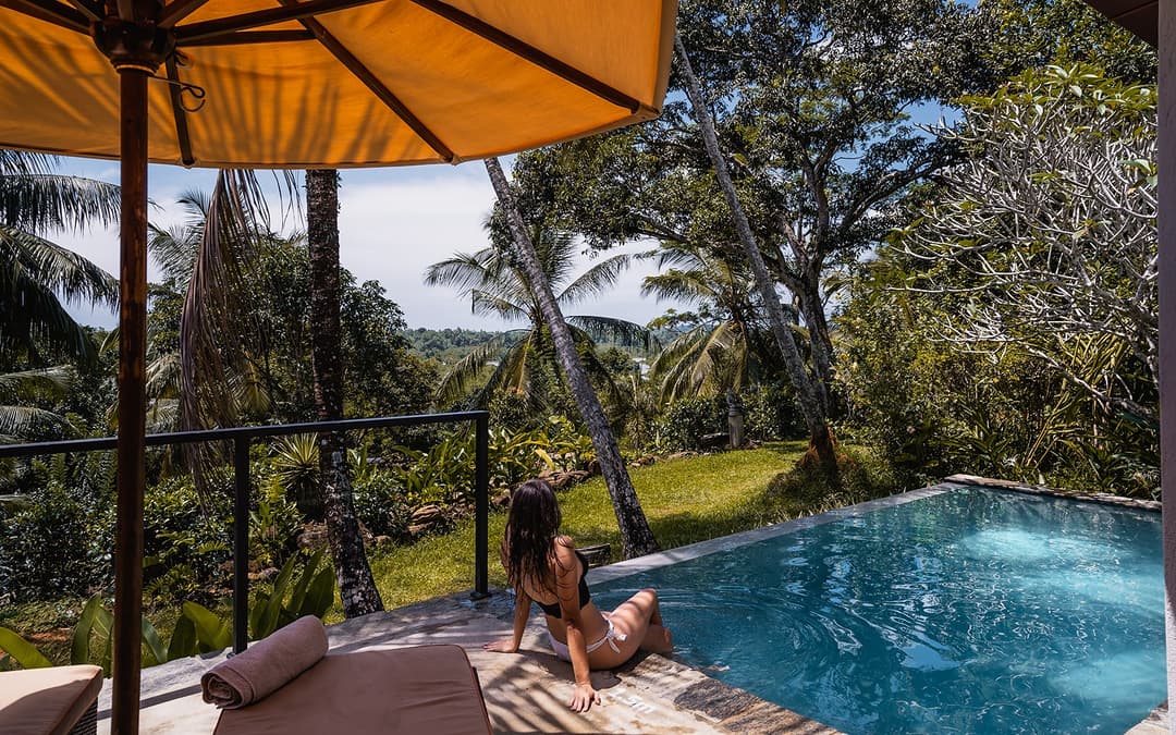 Pool daybed with canopy and tropical garden setting