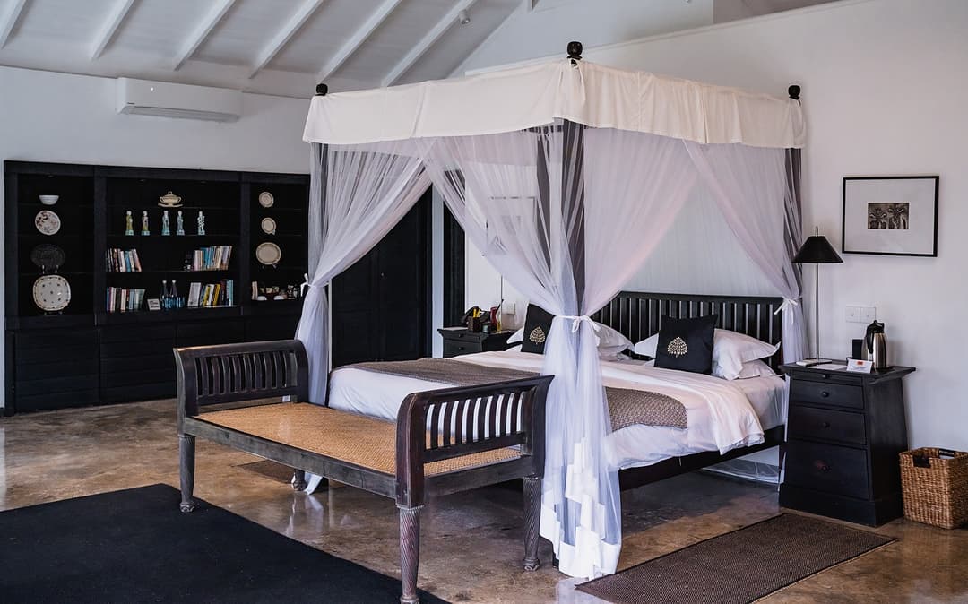 Kahanda Kanda four-poster bed with white canopy and drapes