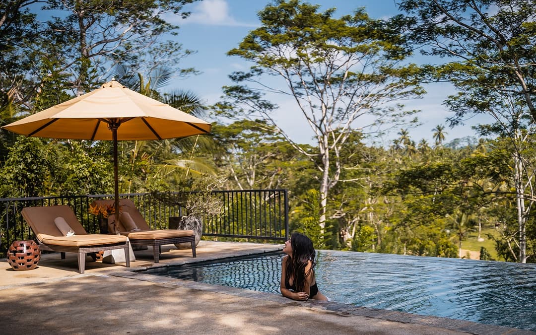 Pool terrace with parasol and lush garden surroundings