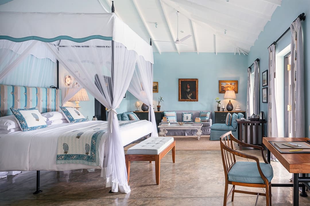 Canopy bed with blue accents and colonial-style furnishings