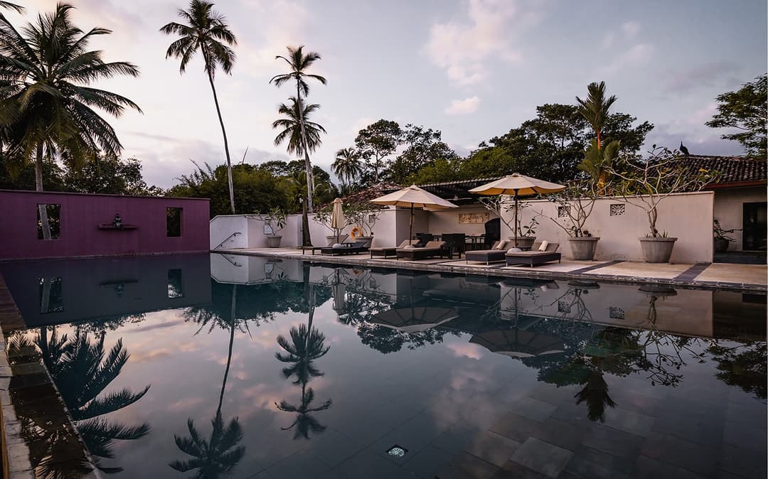 Kahanda Kanda main pool with sun loungers during dusk