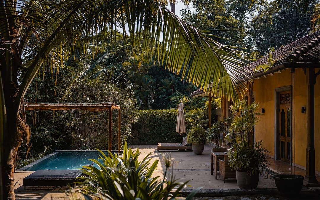 Kahanda Kanda pool deck with parasol and palm tree canopy
