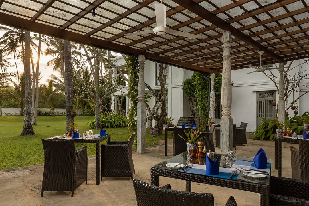 Shaded veranda seating with garden and pool views at Heritage House Bentota, Sri Lanka