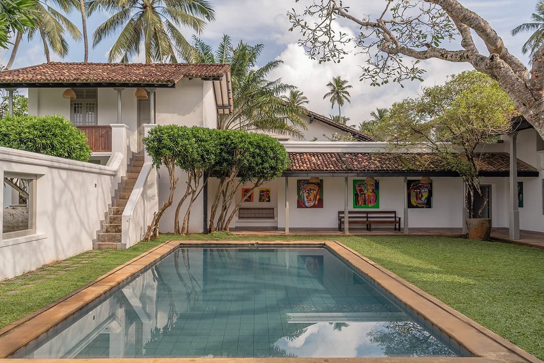 Heritage House Bentota swimming pool with tropical garden and colonial building, Sri Lanka