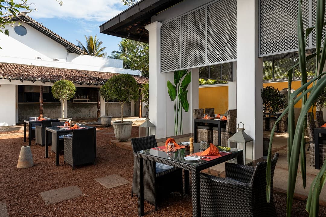 Lounge with colonial furniture and teal cushions at Heritage House Bentota, Bentota