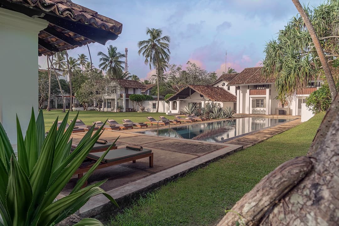 Heritage House Bentota whitewashed colonial facade reflected in the 75-foot swimming pool