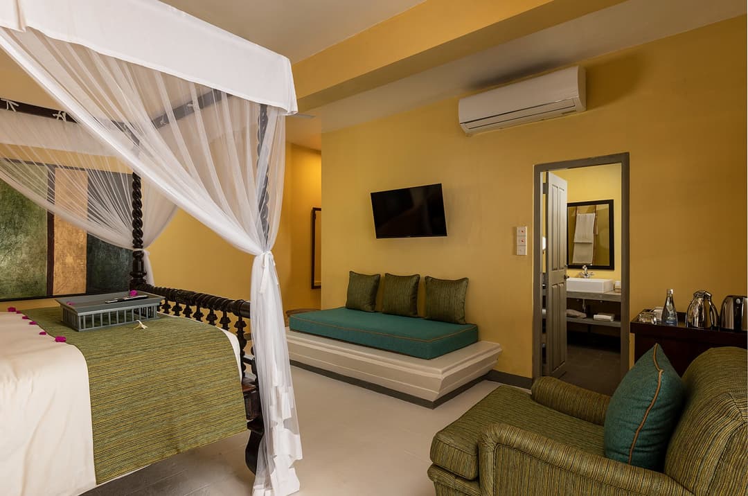 White canopy bedroom with green accent cushions at Heritage House Bentota, Bentota