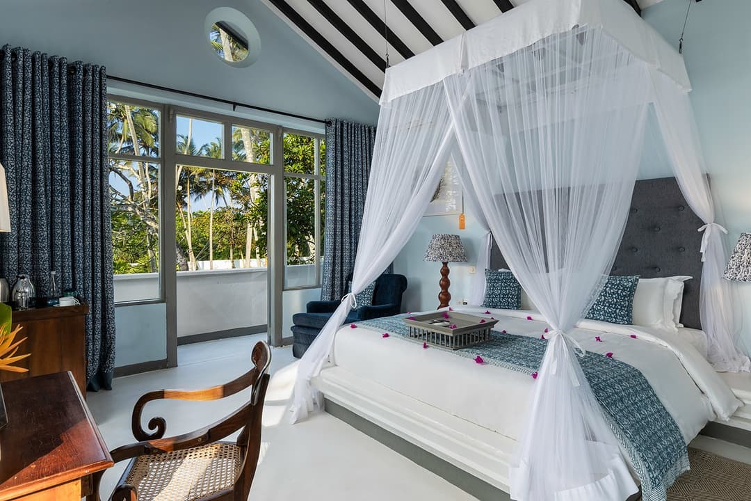 White canopy bedroom with blue ocean-inspired accents at Heritage House Bentota, Sri Lanka