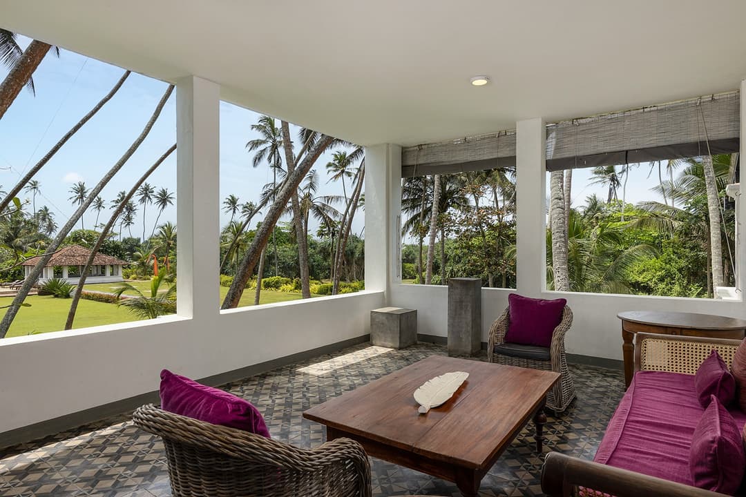 Canopy bedroom opening onto private terrace with garden views at Heritage House Bentota