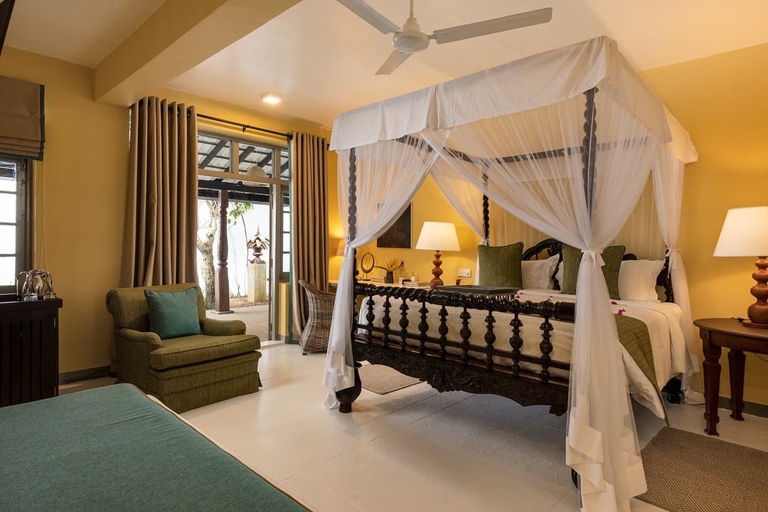 Four-poster canopy bedroom with yellow flower detail at Heritage House Bentota, Sri Lanka