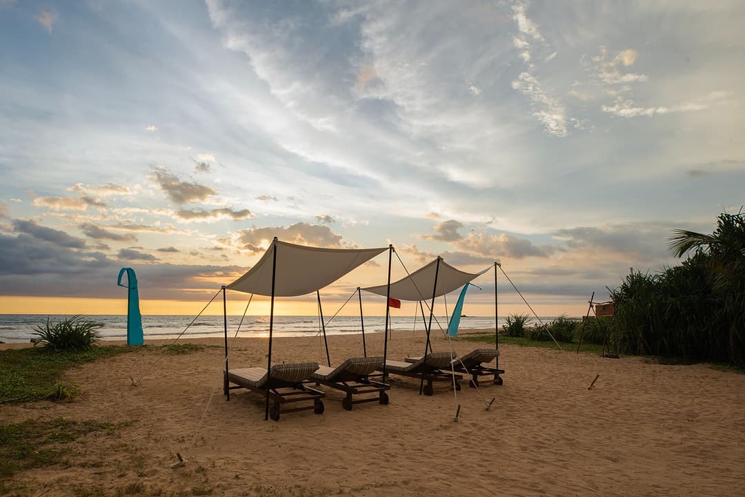 Beach shade loungers at dusk on Bentota beach directly accessible from Heritage House