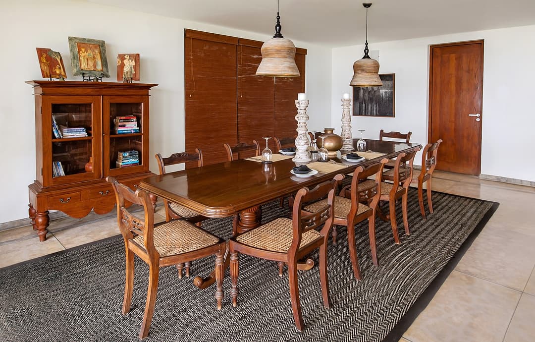 Formal dining room with long timber table and 10 chairs at Cottage Kabalana, Ahangama