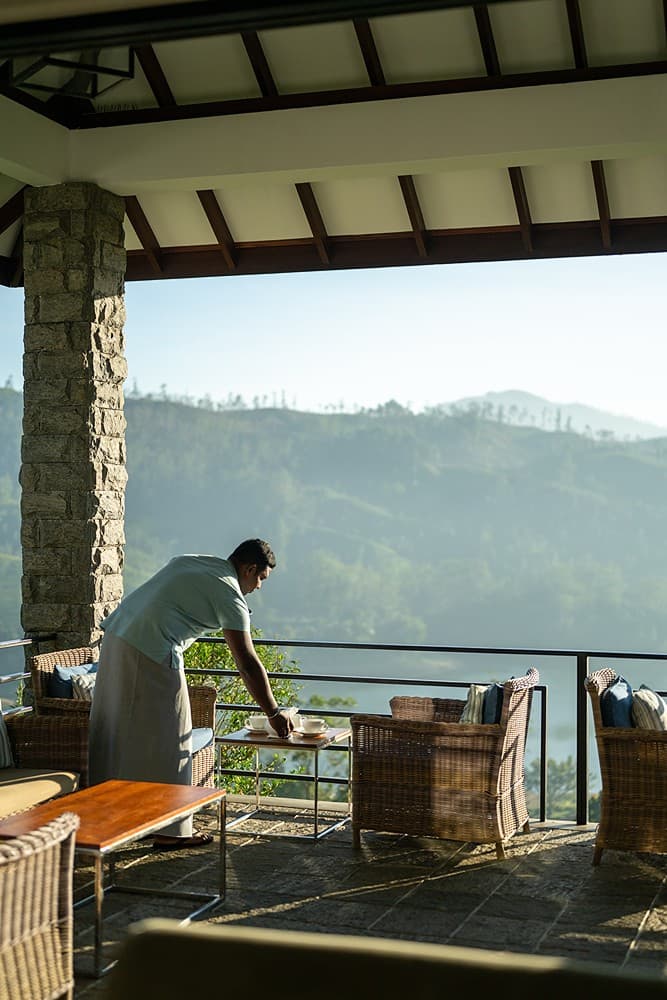 Staff on dining terrace with valley panorama at Camellia Hills, Dickoya, Sri Lanka