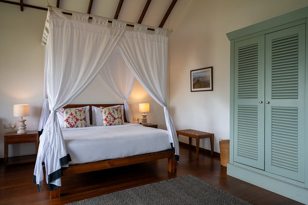 Norton bedroom with louvred shutters and muted green palette at Camellia Hills, Dickoya