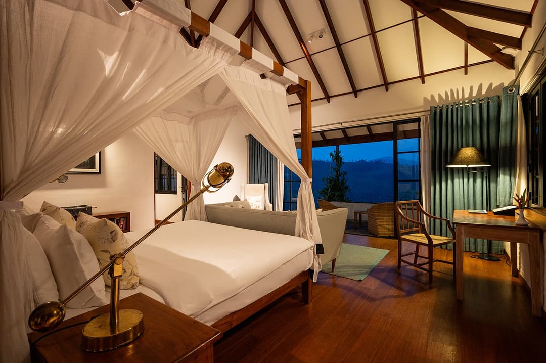Dickoya suite canopy bed with blue accent cushions at Camellia Hills, Dickoya, Sri Lanka