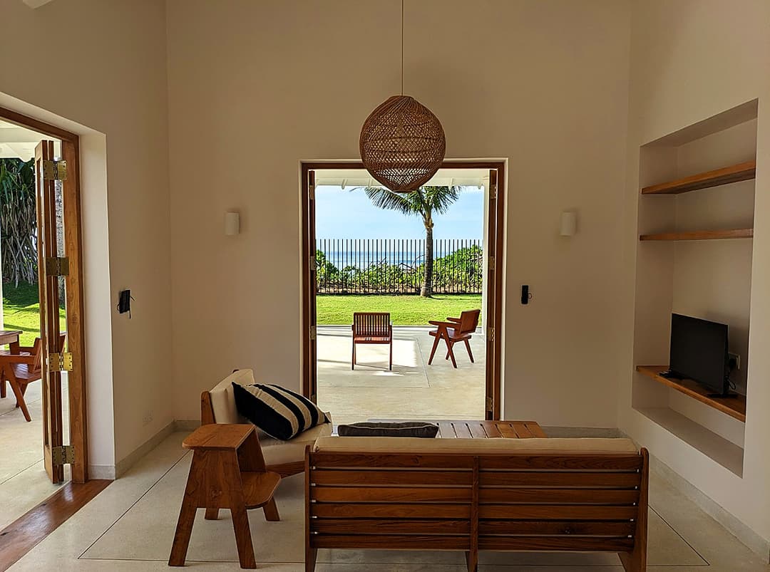 Bedroom interior with rattan pendant lamp and wardrobe at Salt and Stone, Ahangama