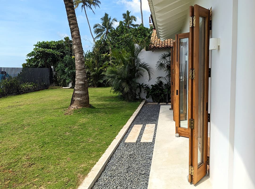 Garden path opening to manicured lawn at Salt and Stone, Ahangama, Sri Lanka