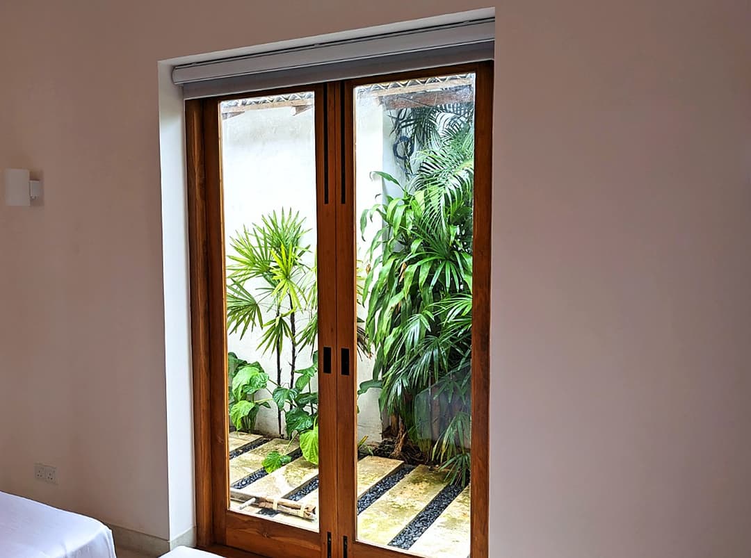 Twin bedroom with sliding door opening to outdoor planting, Salt and Stone, Ahangama