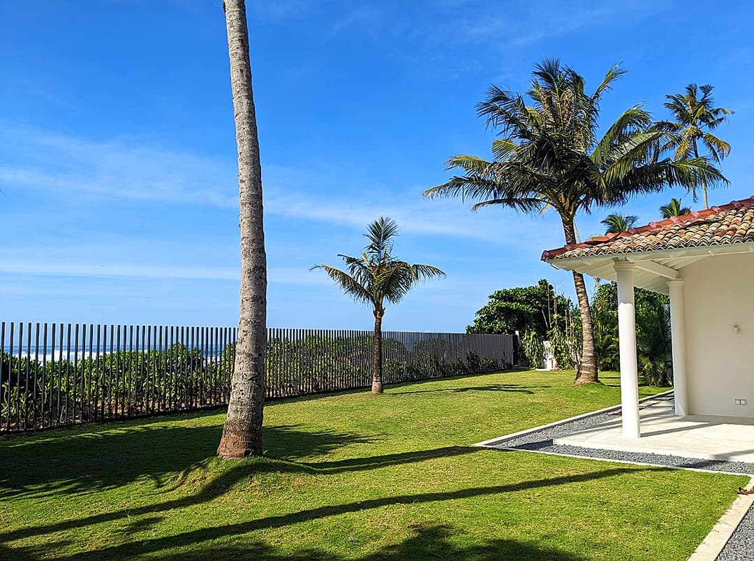 Salt and Stone villa exterior facade with coconut palms and tropical garden, Ahangama