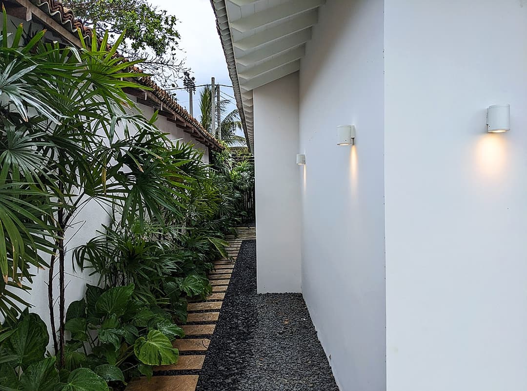 Salt and Stone villa exterior facade with coconut palms and tropical garden, Ahangama