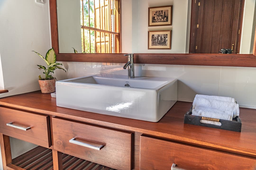 Bathroom with teak vanity and framed mirror at Island Villa Ahangama, Ahangama, Sri Lanka