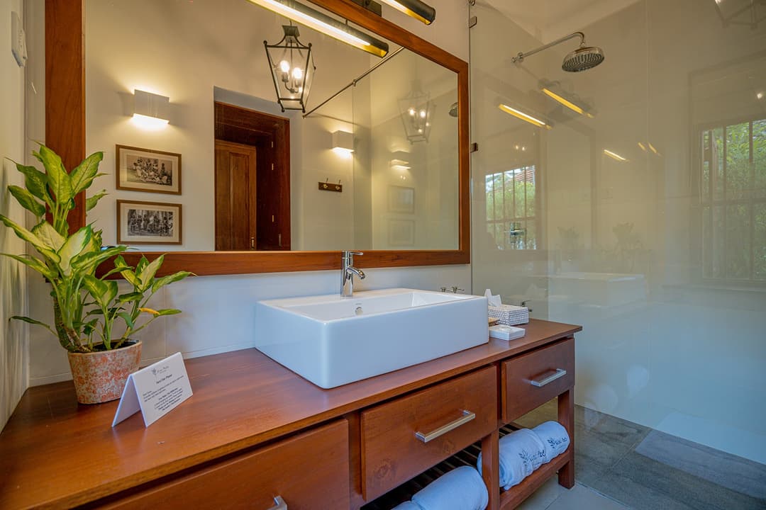 Bathroom with teak vanity and rain shower at Island Villa Ahangama, Ahangama, Sri Lanka