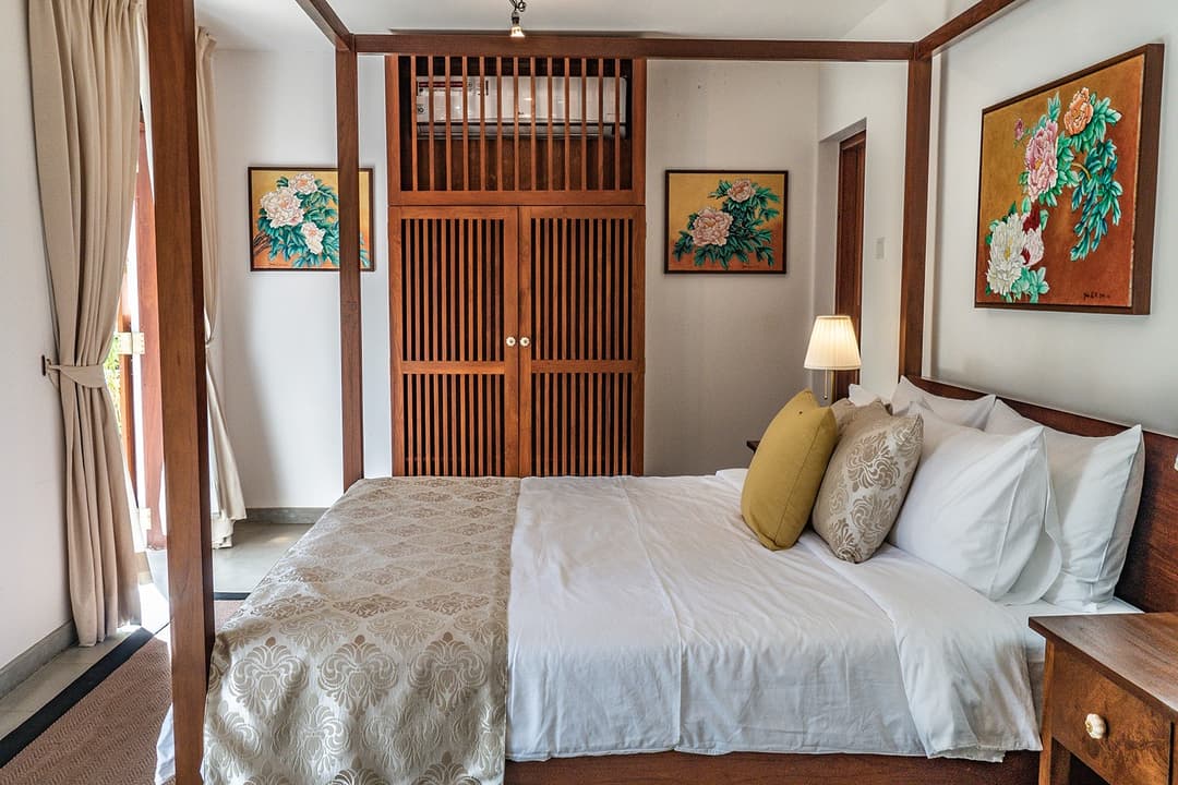 Bedroom with carved headboard and louvred door at Island Villa Ahangama, Ahangama