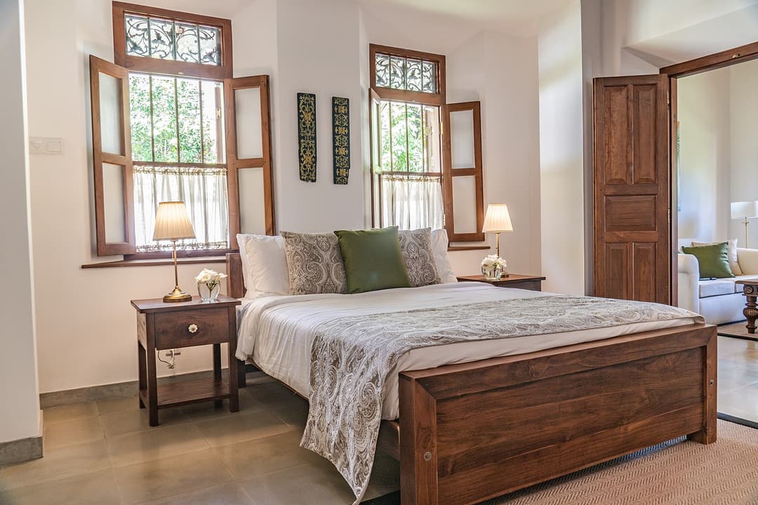 Bedroom with timber bed and louvred wardrobe doors at Island Villa Ahangama, Ahangama